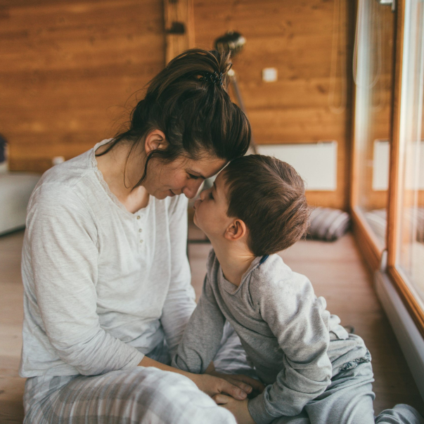 Photo of young mother bonding with her son in a log cabin during winter holidays