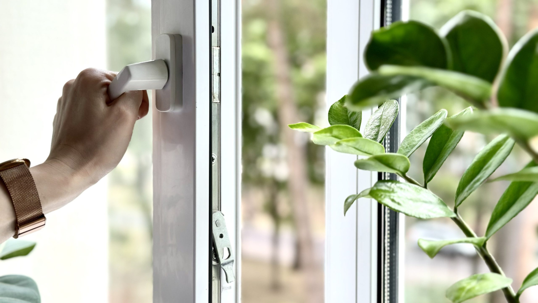 Hand closing the window at cold weather. Winter is coming, close window